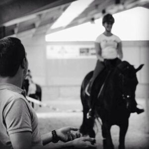 Philippe Minquet begeleidt een ruiter te paard.